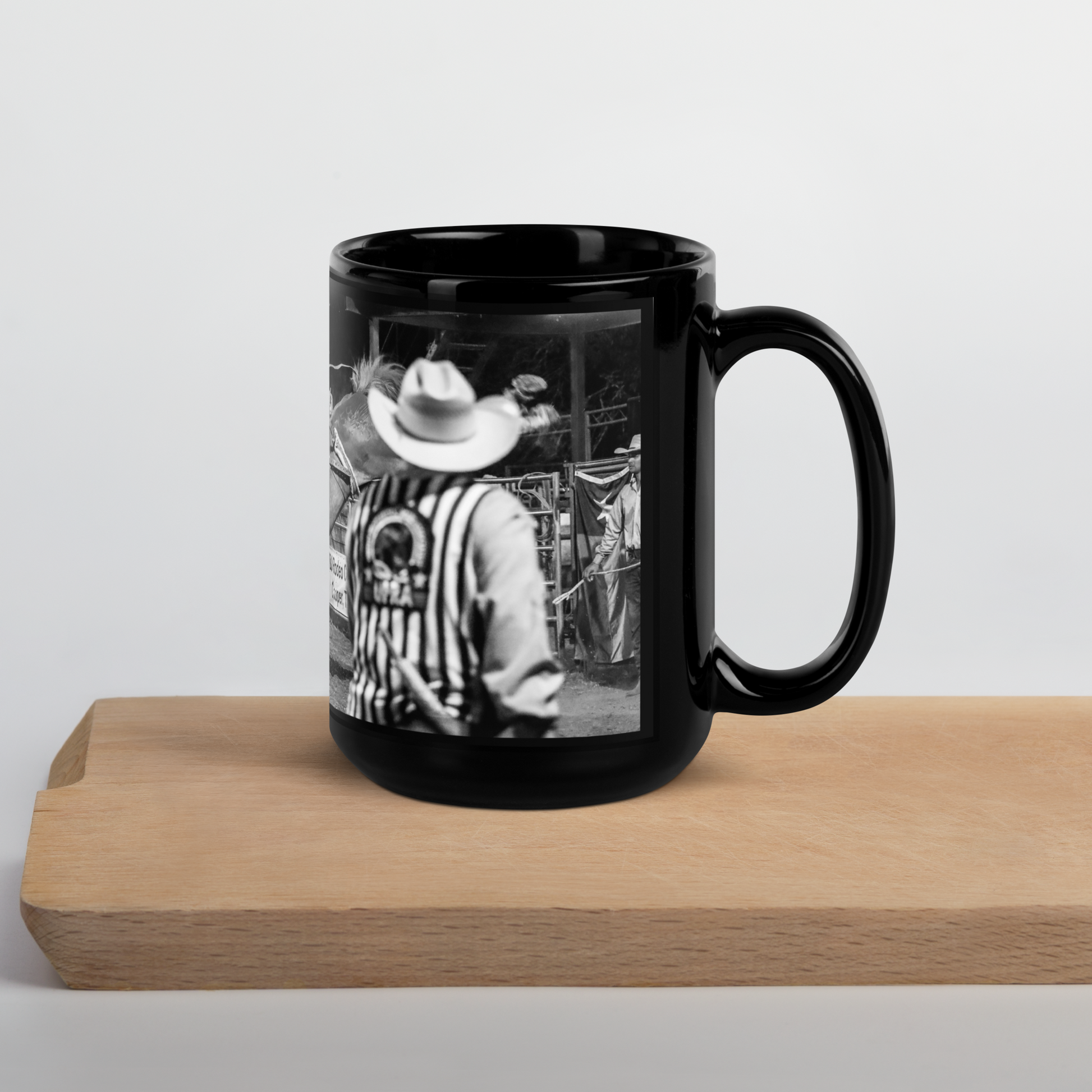 Black coffee cup with a saddle bronc rider at a rodeo