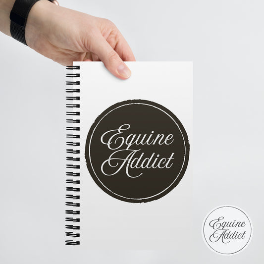 Notebook with 'Equine Addict' branding held by a hand on a light gray background. best notebook for horse girls, white spiral bound journal, horse lovers